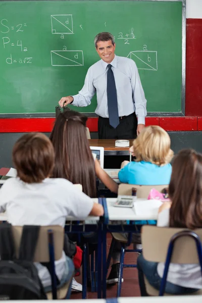 Insegnante guardando gli studenti in aula — Foto Stock