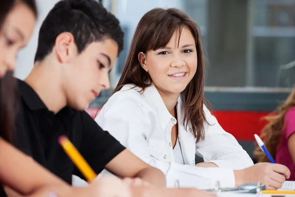 Teenager-Schulmädchen lächelt mit Freunden im Klassenzimmer — Stockfoto