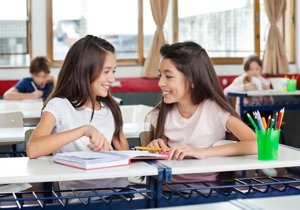 Schoolmeisjes kijken elkaar in klas — Stockfoto