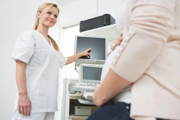 Médico mostrando ultra-som para a mulher grávida — Fotografia de Stock