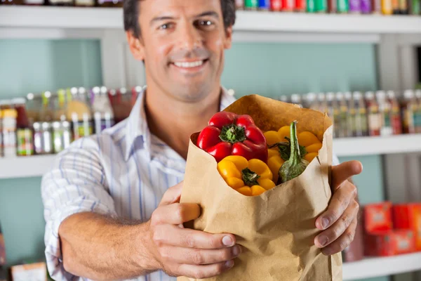 Manliga kunden visar bellpeppers i väska — Stockfoto