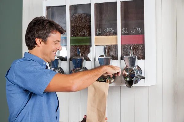 Mann kauft Kaffee am Automaten im Supermarkt — Stockfoto