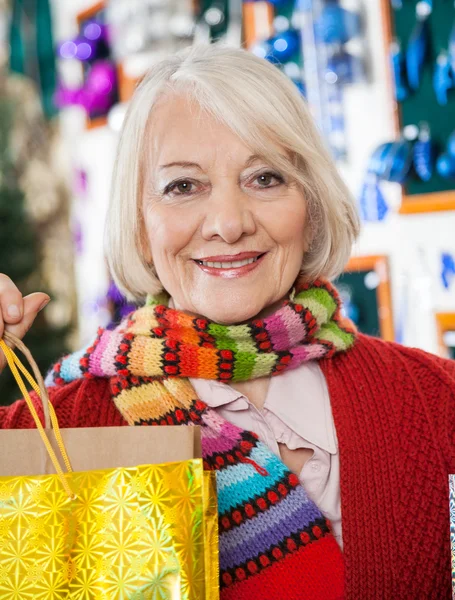 Schöne Frau trägt Einkaufstüten im Laden — Stockfoto
