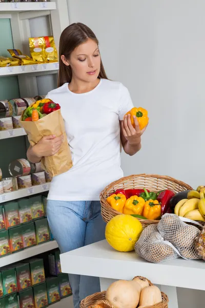 Mulher compras Bellpeppers no supermercado — Fotografia de Stock