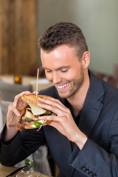 Affärsman anläggning sandwich i coffeeshop — Stockfoto