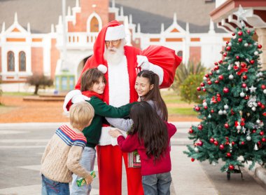 Çocuklar Noel Baba kucaklayan
