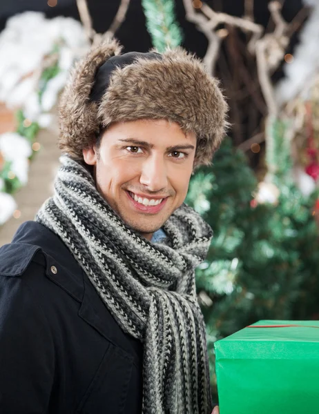 Schöner Mann mit Geschenkbox im Geschäft — Stockfoto