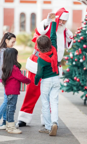 Pojke ger hög fem till jultomten — Stockfoto