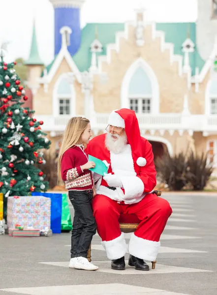 Meisje wens lijst geven santa claus — Stockfoto