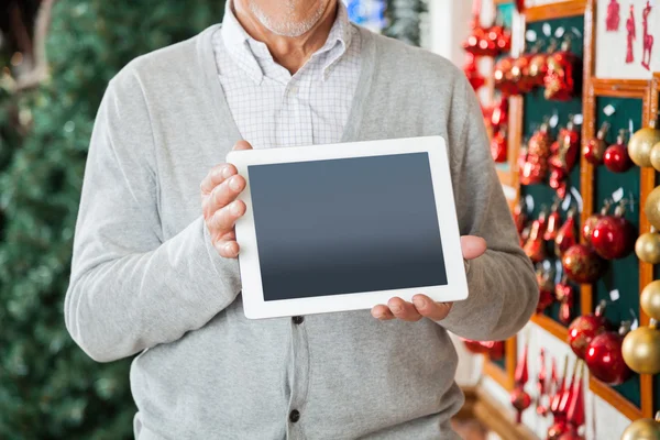 Hombre sosteniendo la tableta digital en la tienda de Navidad — Foto de Stock