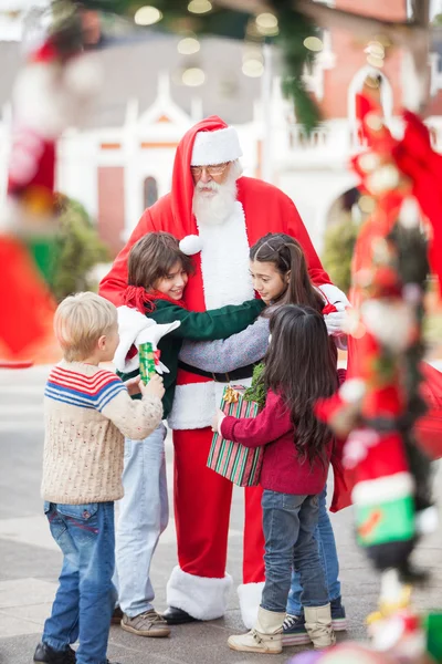 Children Embracing Santa Claus Stock Photo