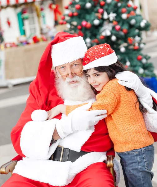 Weihnachtsmann umarmt Mädchen — Stockfoto