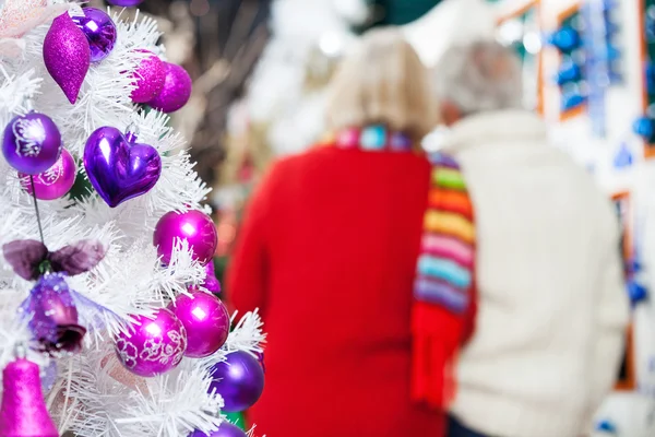 Geschmückter Weihnachtsbaum und Paar im Geschäft — Stockfoto