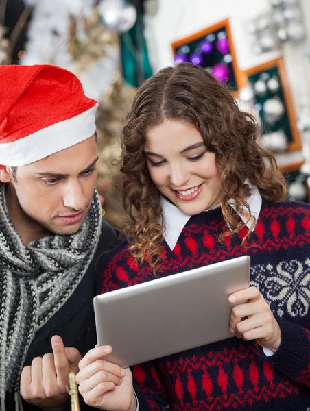 Casal usando tablet digital na loja de Natal — Fotografia de Stock