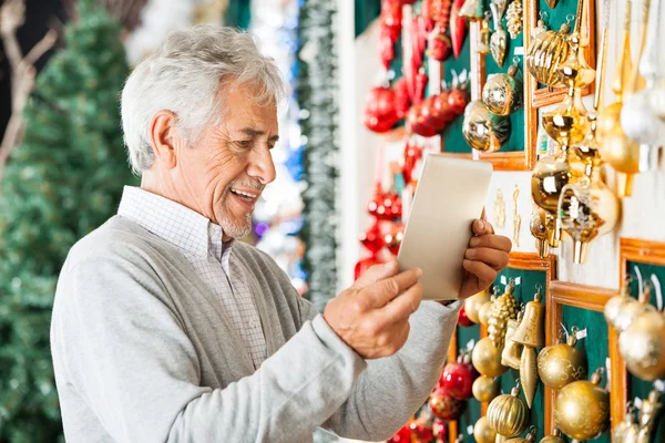 Happy Man Photographing Christmas Ornaments At Store — Stock Photo, Image