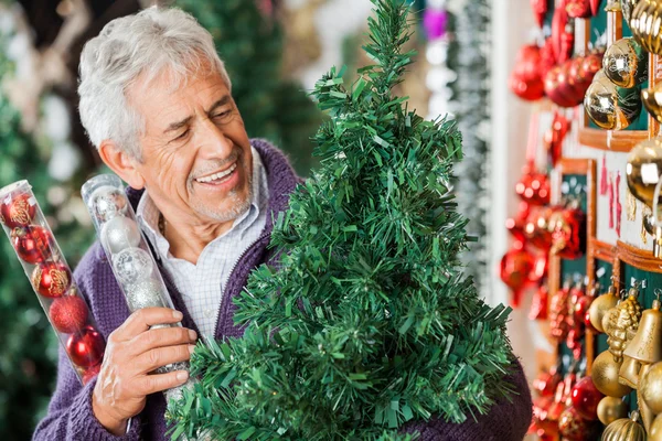 Hombre mirando el árbol de Navidad en la tienda —  Fotos de Stock