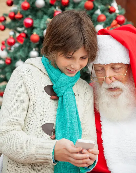 Chlapec ukazuje smartphone s santa claus — Stock fotografie