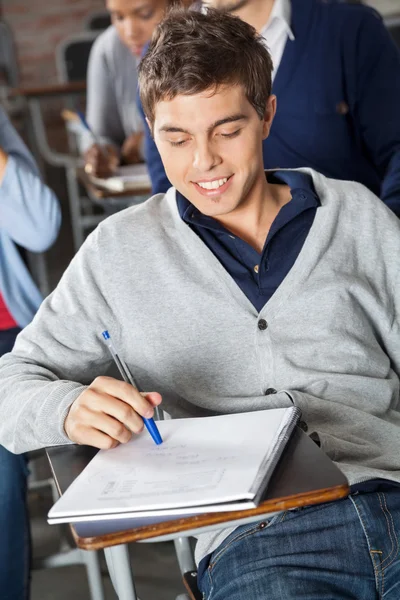 Student Looking At Exam Paper In Classroom Stock Image