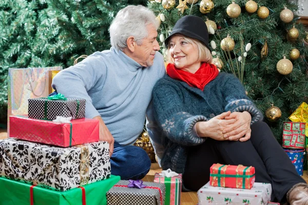 Couple assis avec des cadeaux dans le magasin de Noël — Photo