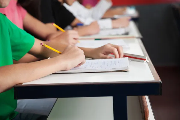 High School Students Writing On Paper At Desk — Stock Photo, Image