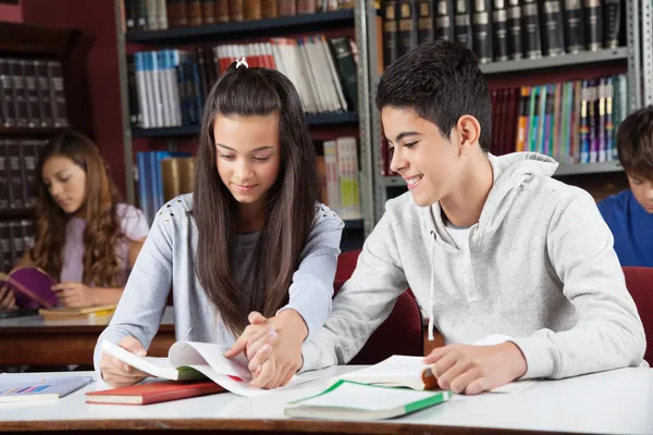 Amici che studiano insieme mentre tengono le mani alla scrivania — Foto Stock