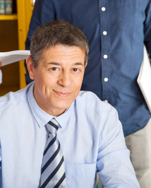 Confident Teacher Smiling With Student Standing In Background At — Stock Photo, Image