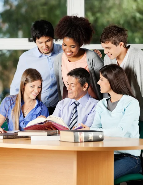 Professor Explaining Students At Desk In Classroom — Stock Photo, Image