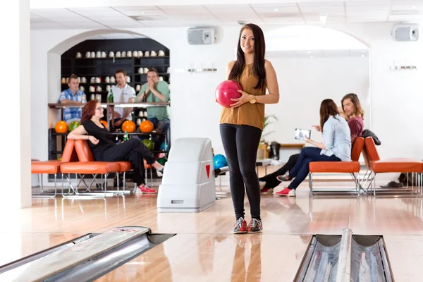 Donna che tiene palla in Bowling Alley — Foto Stock