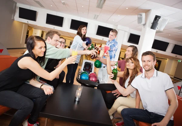 Freunde stoßen im Kegelclub auf Getränke an — Stockfoto