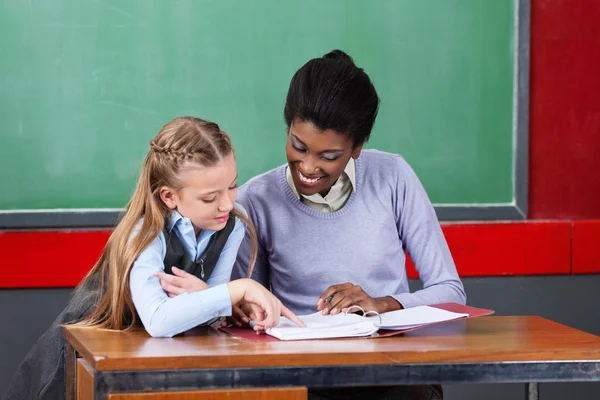 Teacher And Schoolgirl Reading Together At Desk — Stock Photo, Image