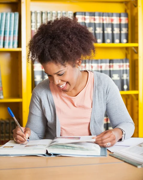 Student schriftelijk boek bij de bibliotheek van de Universiteit — Stockfoto