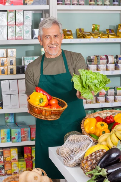 Senior säljare säljer grönsaker på stormarknaden — Stockfoto