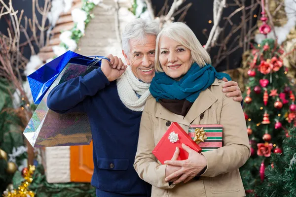 Coppia con shopping borse e presente al negozio di Natale — Foto Stock