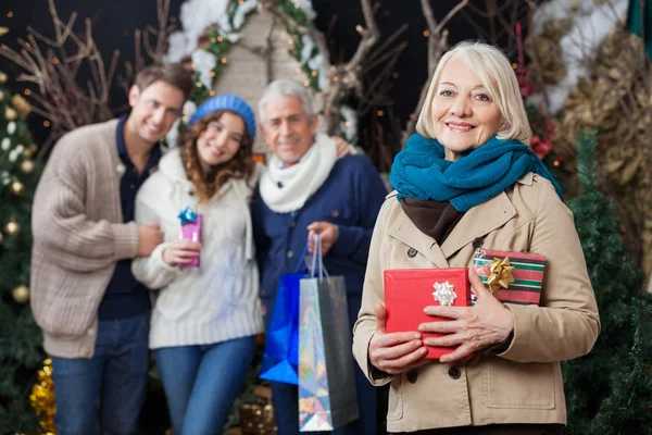 Lycklig familj med julklappar i butik — Stockfoto