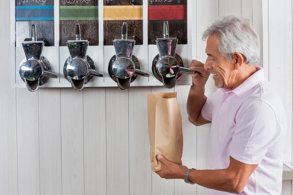 Hombre mayor comprando granos de café en la tienda de comestibles —  Fotos de Stock