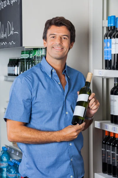 Man Displaying Wine Bottle In Supermarket — Stock Photo, Image