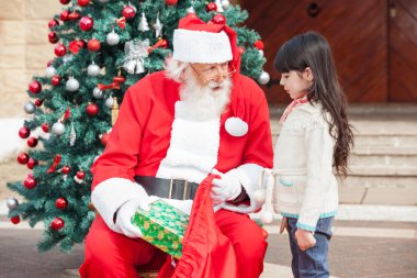 Santa Claus Giving Gift To Girl