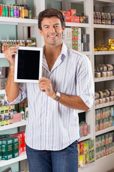 Hombre mostrando tableta digital en supermercado — Foto de Stock