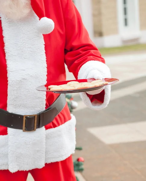 Santa claus drží desku s cookies — Stock fotografie