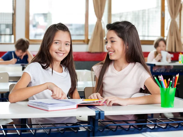 Happy Schoolgirl Sentado com amigo na mesa — Fotografia de Stock