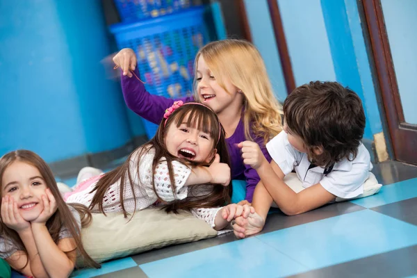 Bambini giocosi sdraiati sul pavimento — Foto Stock