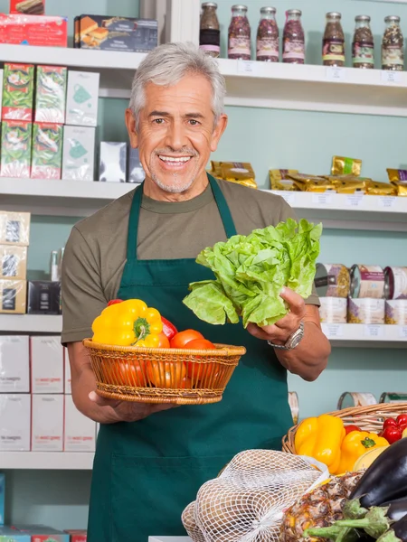 Senior verkoper verkoop van groenten in winkel — Stockfoto