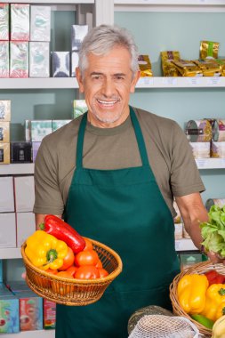 Senior Salesman Holding Vegetable Basket