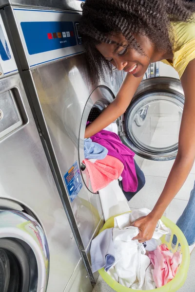 Frau lädt schmutzige Wäsche in Waschmaschine — Stockfoto
