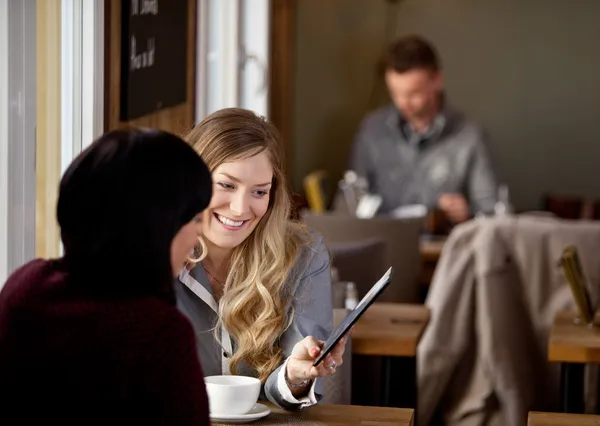 Vrouw weergegeven: digitale Tablet PC aan vriend — Stockfoto