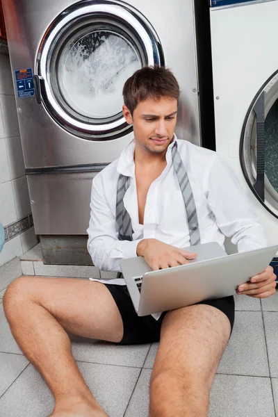 Businessman Using Laptop In Laundromat — Stock Photo, Image