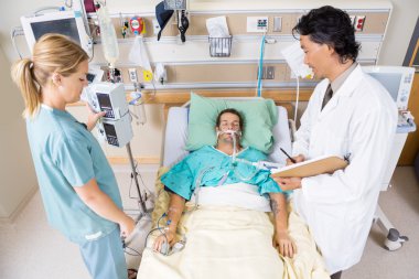 Doktor ve hemşire kritik hastanın incelenmesi