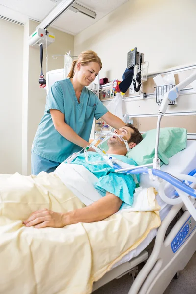 Krankenschwester justiert Patientenkissen — Stockfoto