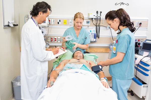 Médico e enfermeiras tratando paciente crítico — Fotografia de Stock