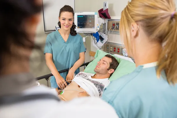 Sjuksköterskor och läkare undersöka patient — Stockfoto